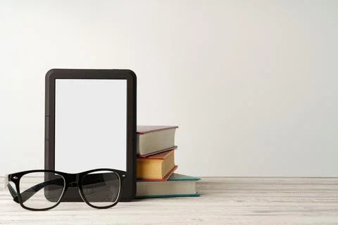 Stack of books and digital tablet on wooden desk Foto stock