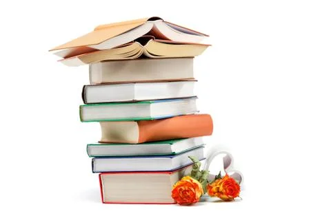 A stack of books and flowers on a white background. Stock Photos
