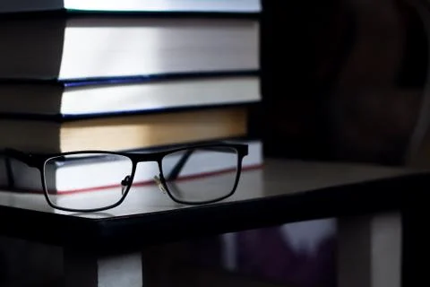 Stack of books and glasses closeup in the dark 写真素材