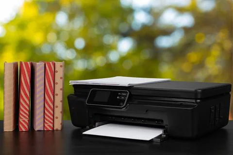 Stack of books and home printer against blurred background 스톡 사진