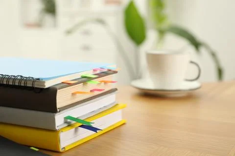 Stack of books and notebook with colorful bookmarks on wooden table, closeu.. Stock Photos