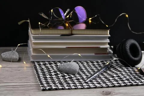 Stack of books and notepads on which are glasses and on the side of headphones Stock Photos