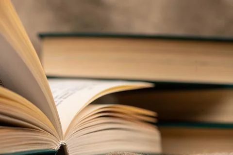 A stack of books and an open book on the table. Close-up, selective focus 库存照片