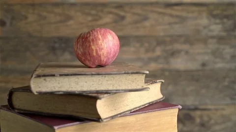 Stack of books and red apple rotating. Wooden background, Copy space Stock Footage 71900677