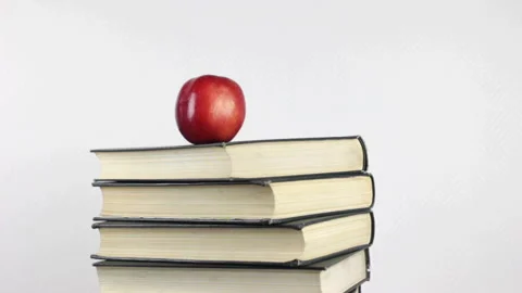 A stack of books and a red apple rotating Stock Footage 233478584