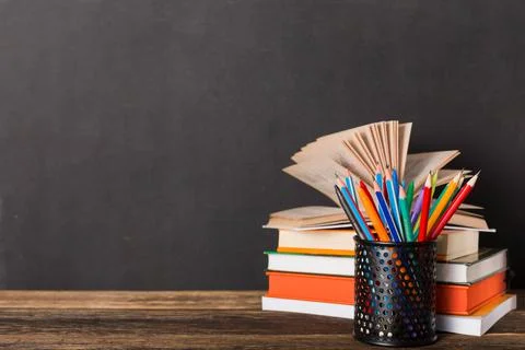 Stack of books and stationery on the background of the school board 스톡 사진