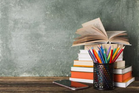 Stack of books and stationery on the background of the school board. 스톡 사진