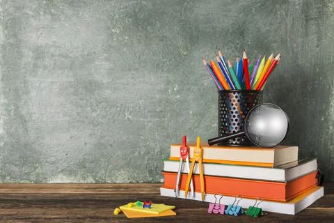 Stack of books and stationery on the background of the school board 写真素材