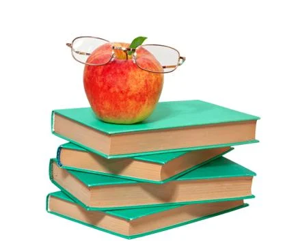 Stack of books with an apple and glasses on a white background Stock Photos