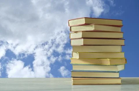 Stack of books with blue sky and clouds background, inspiration,imagination.. Stock Photos