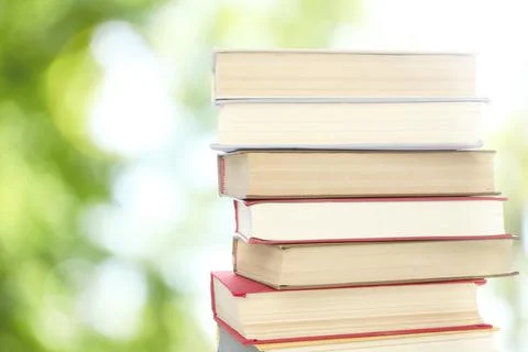 Stack of books on blurred background, space for text. Bokeh effect Stock Photos