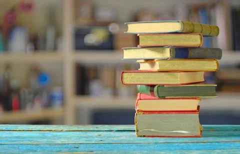 Stack of books with blurred bookshelf background, reading, learning, educat.. Stock Photos