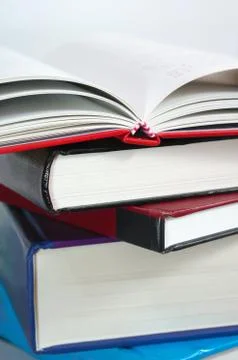 Stack of books with book open on top Stock Photos