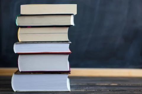 Stack of books with chalkboard in background Stock Photos