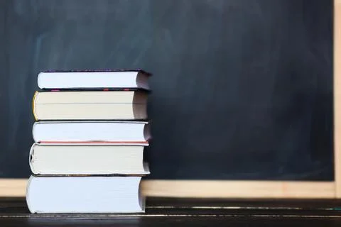 Stack of books with chalkboard in background . Space for your text Stock Photos