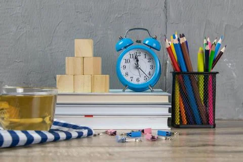 A stack of books, a clock, wooden cubes in the shape of a pyramid, next to th Stockfoto's