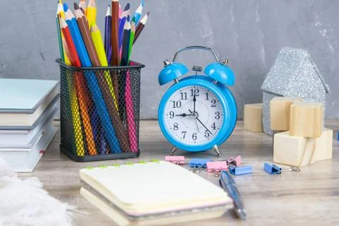 A stack of books, a clock, wooden cubes in the shape of a pyramid, next to th Stock Photos
