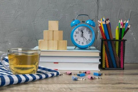A stack of books, a clock, wooden cubes in the shape of a pyramid, next to th Stockfoto's