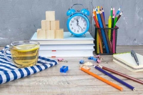 A stack of books, a clock, wooden cubes in the shape of a pyramid, next to th Stockfoto's