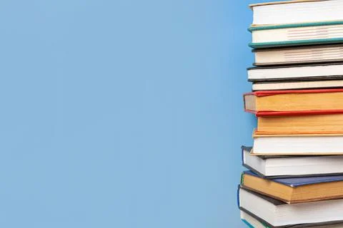 Stack of books in the colored cover lay on blue backround. Education learni.. 写真素材