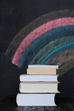 Stack of books with colorful chalkboard in background Stock Photos