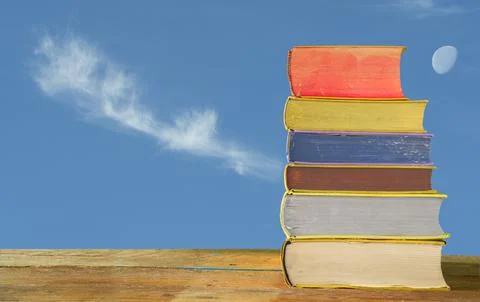 Stack of books with densely wooded  mountains in the background copy space Stock Photos