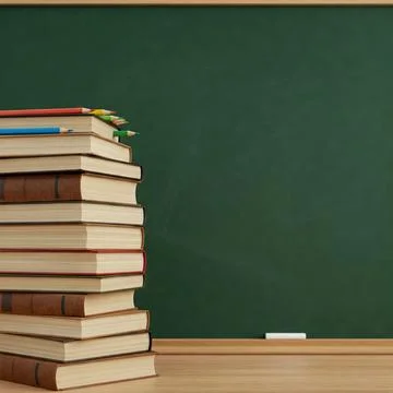 A stack of books on a desk on front of a school classroom blackboard Stock Photos
