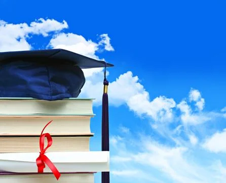 Stack of books with diploma against blue sky Stock Photos