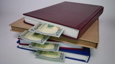 Stack of books with dollars appearing from them. Stop motion Stock Footage 315412934