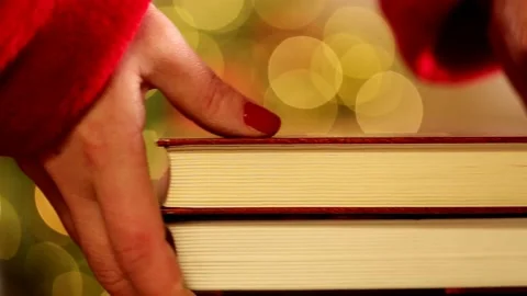 Stack of books in female hands  on shimmering Christmas tree backgroun Stock Footage 211003193