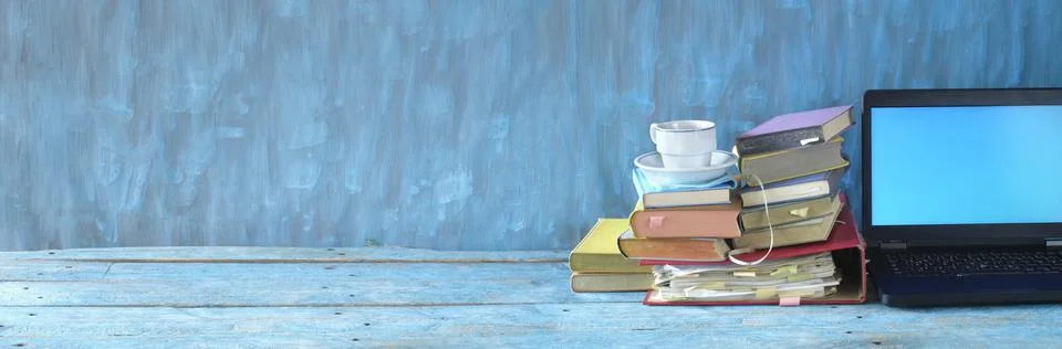 Stack of books, file folder and old laptop computer,home office, e-learning Stock Photos