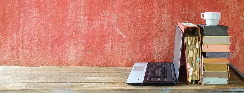 Stack of books, file folder and old laptop computer,home office,homeschooling Stock Photos