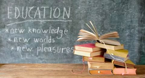 Stack of books in front of a blackboard.Back to school, education concept Stock Photos