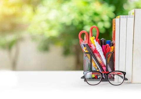 A stack of books, glasses, stationery on a table. Stock Photos