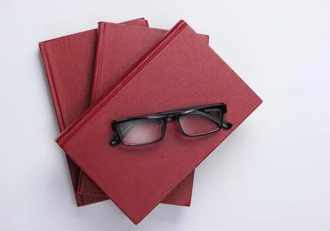 Stack of books with glasses on white background. Library, education. Top view Stockfoto's