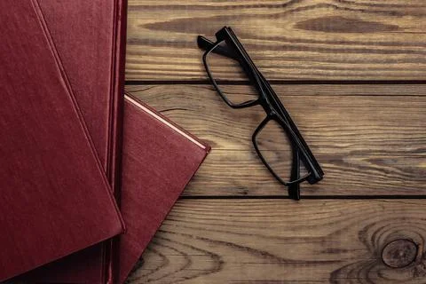 Stack of books with glasses on a wooden background. Library, book lover. Top  Stockfoto's