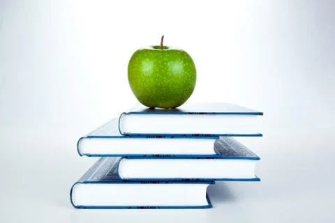Stack of books with green apple Stock-Fotos