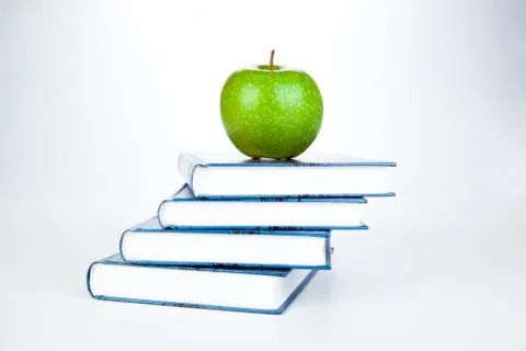 Stack of books with green apple Stock Photos