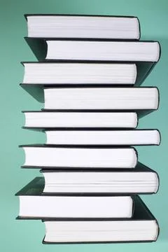 A stack of books on a green background, side view Stock Photos