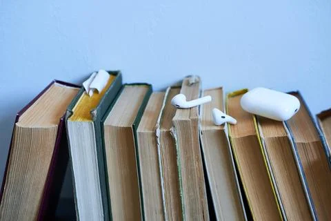 Stack of books with headphones on blue background. 스톡 사진