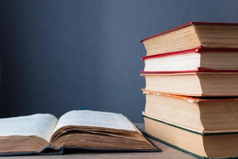 Stack of books lies on table, one of them is open. with copy space. Stock Photos
