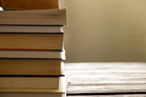 A stack of books lies on a wooden table at home Stock Photos