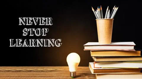 Stack of books with a light bulb on top of them Stock Photos