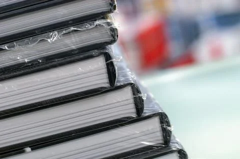 Stack of books with new publications wrapped in foil Stock Photos