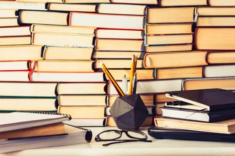Stack of books, notebook, laptop, glasses in office background for education  Stock Photos