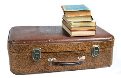 A stack of books on an old leather suitcase isolated on a white background.. Stock Photos