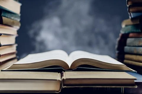 Stack Of Books With One Opened Among Them Stock Photos