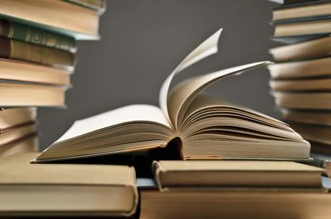 Stack Of Books With One Opened Among Them Stock Photos