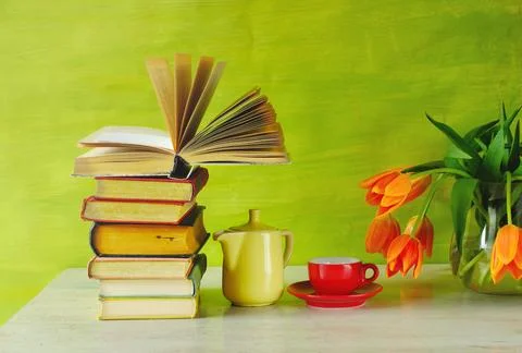 Stack of books with open book, cup of espresso coffee and a bunch of flower.. Stock Photos