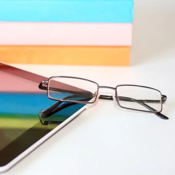 Stack of books with a pair of eyeglasses Stock Photos